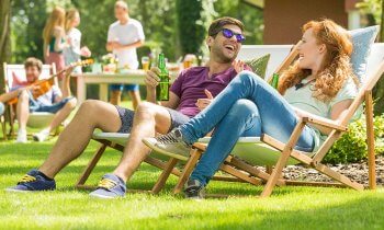 Summer Pests: Backyard celebration with family in background and couple sitting in lawn chairs in the front.